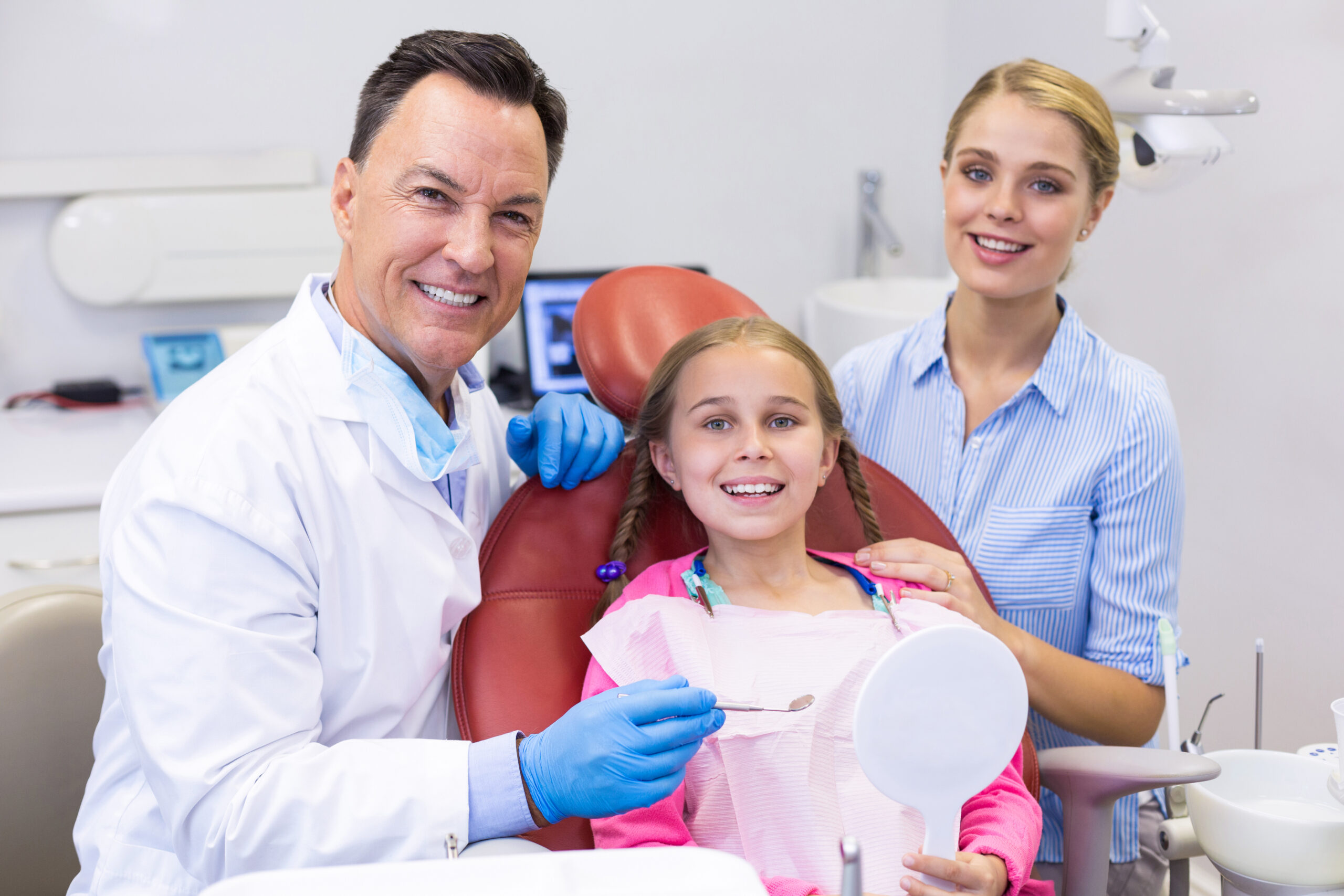 Family smiling with dentist during dental checkup at Loves Park IL